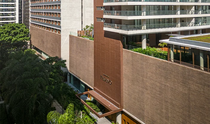 fachada do prédio Fasano Itaim, mostrando a seção de tijolinhos característica da marca fasano na fachada. Há um podium, e, em cima dela, ficam as piscinas e áreas de lazer <span height=