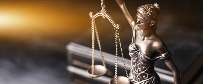 foto de uma escultura, com a imagem da justiça, ou seja, uma mulher segurando uma balança e de olhos vendados