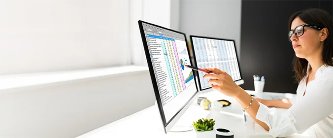 foto de uma mulher em frente a dois computadores