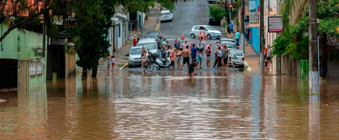 imagem de uma rua em são paulo com muito acúmulo de água embaixo e pessoas reunidas ao fundo