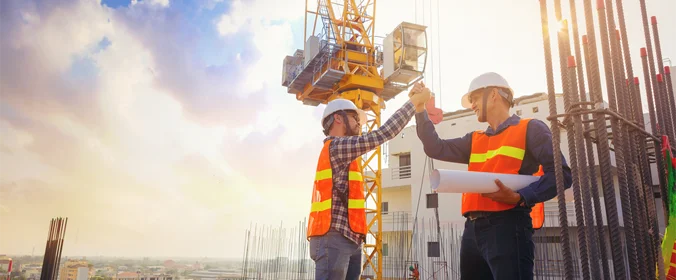 dois trabalhadores em um canteiro de obras se cumprimentando como se estivessem animados