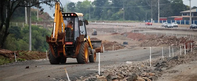 foto de um trator trabalhando na via que está sendo duplicada