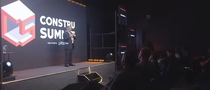 Palestra durante o Construsummit, com homem no palco e plateia lotada