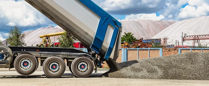 foto de um caminhão despejando areia em um canteiro de obras