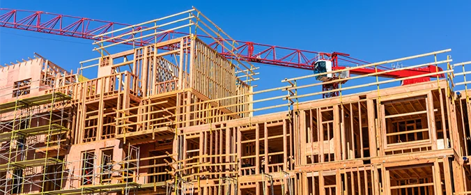 foto de uma construção em andamento, com várias estruturas de madeira e andaimes em volta  