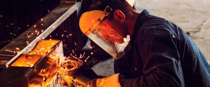 imagem de um trabalhador da área industrial, ele manuseia aparatos de serralheria  