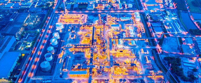 visão aérea noturna de uma grande indústria toda iluminada