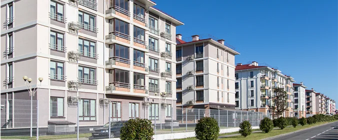 foto de prédios baixos, um ao lado do outro, em uma avenida  