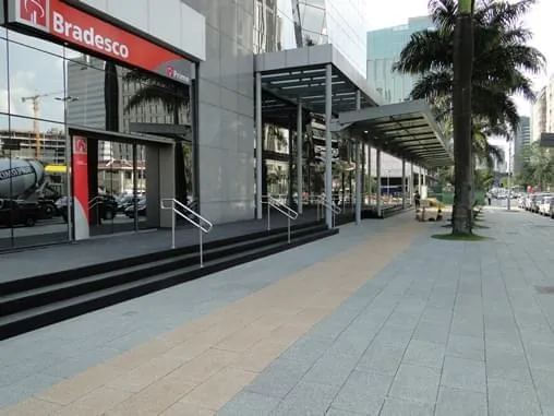 Pisos permeáveis e antiderrapantes geram drenagem eficiente em calçada de banco