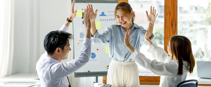 foto de três pessoas batendo as mãos em comemoração
