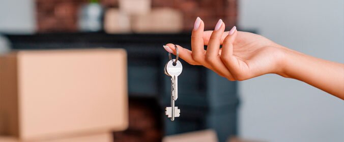 mao feminina segurando um molho de chaves e o fundo desfocado