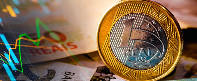 foto macro de uma moeda de 1 real da moeda brasileira e alguma cédulas atrás