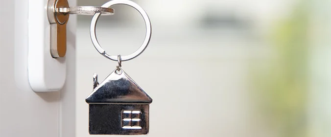 foto de um chaveiro de casinha, na chave de uma porta