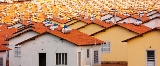 foto de várias casas semelhantes, construídas uma ao lada da outra, em um programa habitacional