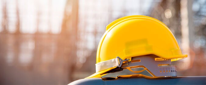 capacete de proteção utilizado em canteiros de obras sobre uma bancada com o fundo desfocado