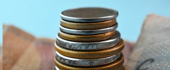 foto de moedas sobre uma cédula