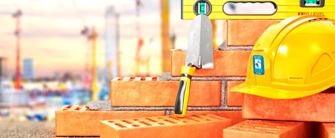 foto de equipamentos de construção, como capacete, nivelador, pá, tijolos e concreto