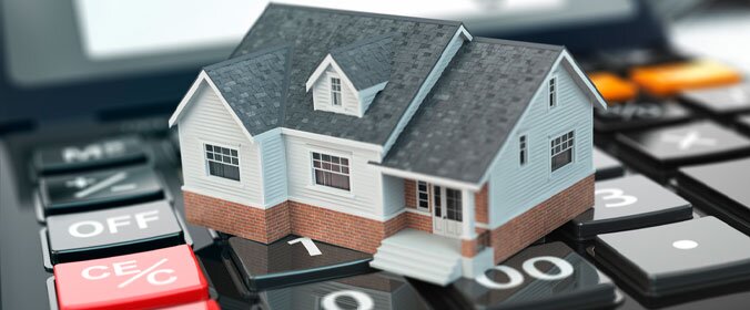 foto de uma casa de brinquedo sobre uma calculadora