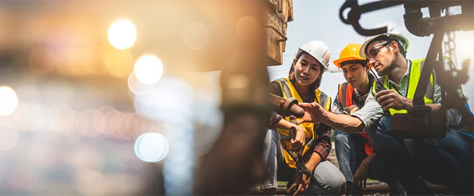 pessoas com equipamentos de segurança manipulando maquinas industriais