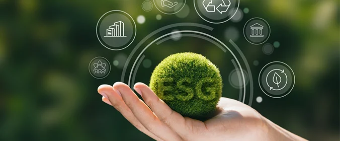 foto de uma mão segurando uma bola feita de grama com as letras ESG em cima