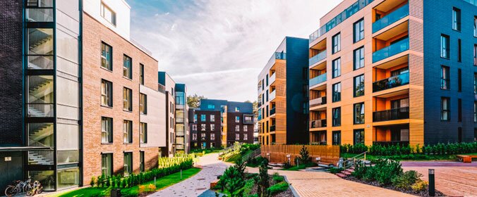 conjunto habitacional com vários prédios, que nao sao muito altos, mas contam com grande arborização na parte térrea