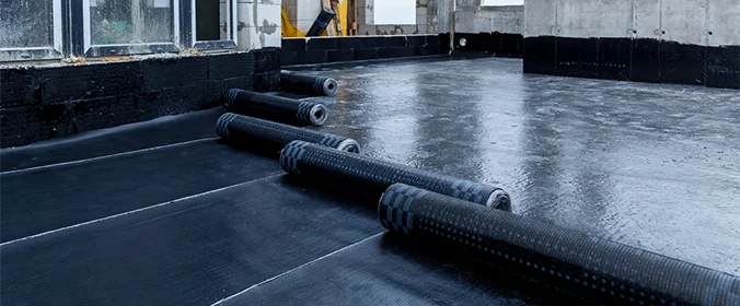 foto de um ambiente sendo impermeabilizado com varias mantas pretas sobre o chão